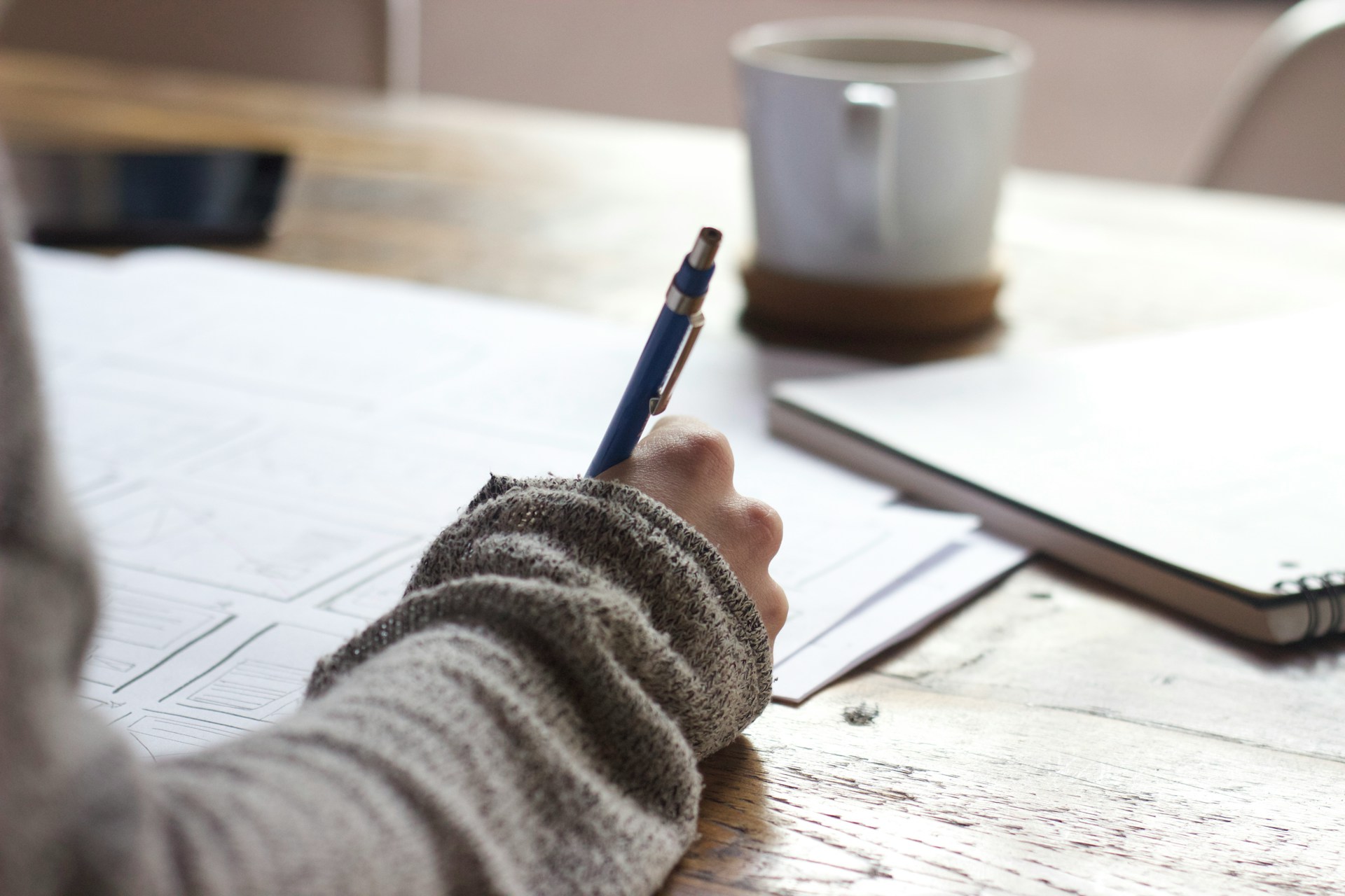 Person writing in a notebook studying,